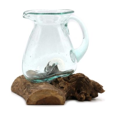 Pichet à eau en verre soufflé avec son anse, posé sur une racine